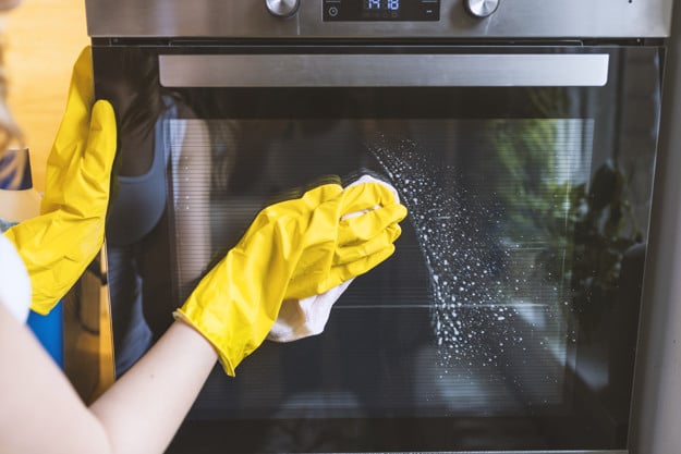 How do I clean my oven without damaging it?